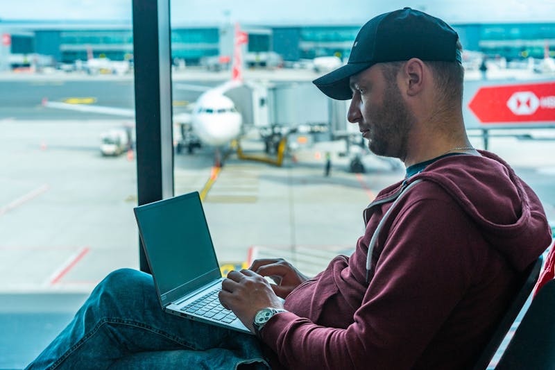 Person working on laptop at airport with no internet connection